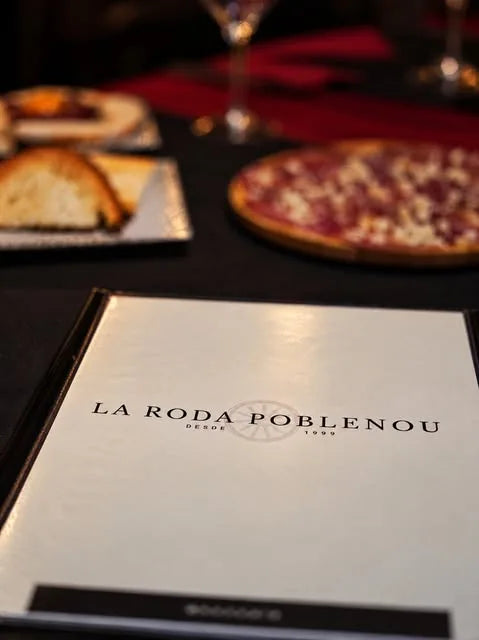 Carte de La Roda Poblenou sur une table avec des plats et des verres